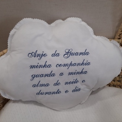 Almofada branca em forma de nuvem com bordado azul com texto em português