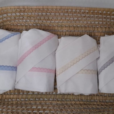 Panosp brancos com bordados coloridos numa cesta de vime