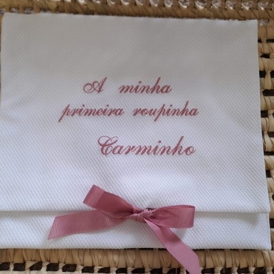 Fralda branca bordada com texto cor-de-rosa e laço cor-de-rosa escuro