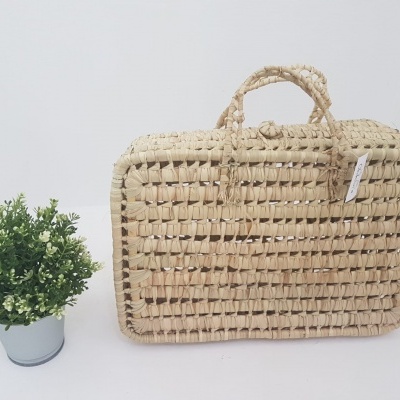 Mala de mão retangular em ráfia natural e vaso pequeno com planta artificial