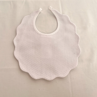 Babete branco com textura em padrão de colmeia e bordas onduladas