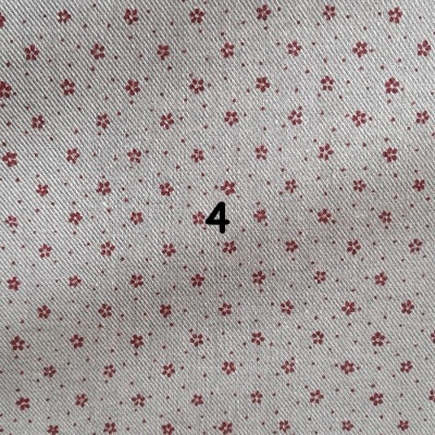 Tecido branco com pequenas flores vermelhas e número 4 preto
