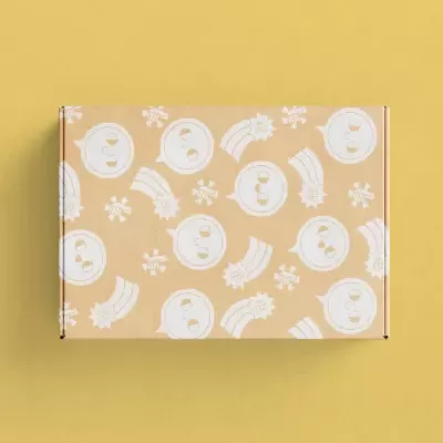 Caixa retangular com padrão repetido de relógios de areia, estrelas e arcos em fundo castanho sobre superfície amarela.