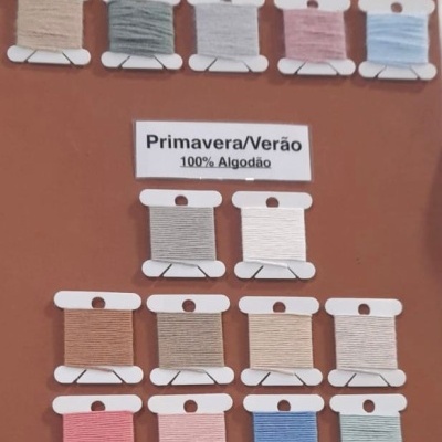 Rolos de linha para costura organizados por estação em mostruário.