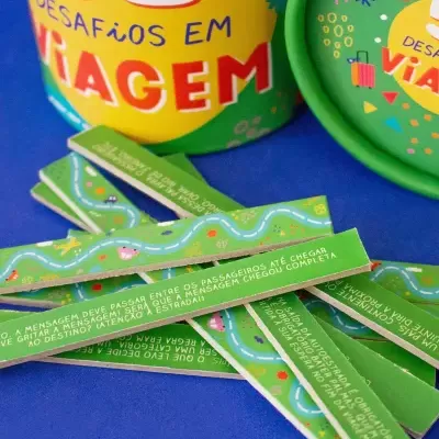 Tiras de papel verdes com texto e ilustrações de estradas ao lado de um cilindro colorido com texto
