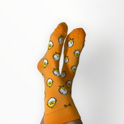 Meias laranja com padrão de ovos estrelados em fundo branco