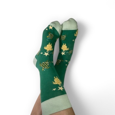 Meias verdes com padrão de tartarugas e estrelas amarelas