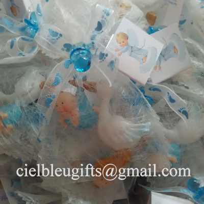 Pacotes decorativos para lembranças de bebé com fitas azuis e bonecos pequenos