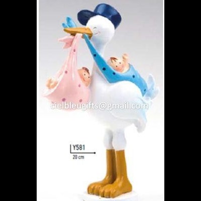 Figura decorativa de cegonha com bebés em fundo cinzento