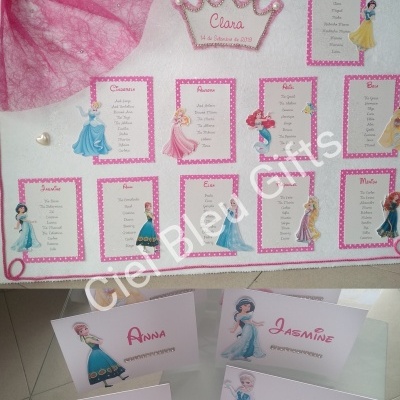 Painel de convidados decorado com personagens Disney e cartões de nomes em mesa branca
