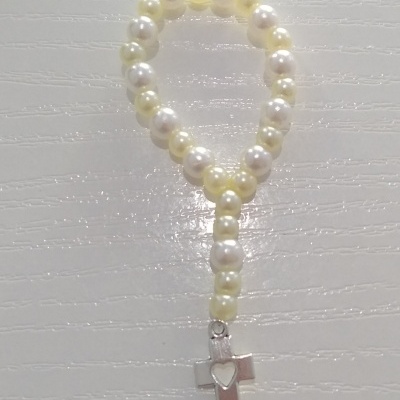 Pulseira de contas peroladas com pingente de cruz metálica