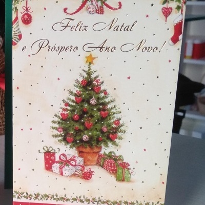 Cartão de Natal com árvore decorada, presentes e texto Feliz Natal e Próspero Ano Novo