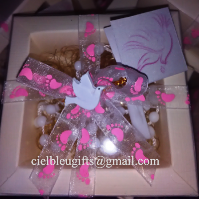 Caixa de oferta com fita cor-de-rosa, pomba branca e pulseira branca dentro