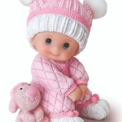 Boneco vestido de rosa e branco sentado com brinquedo de peluche rosa