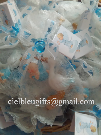Pacotes decorativos para lembranças de bebé com fitas azuis e bonecos pequenos