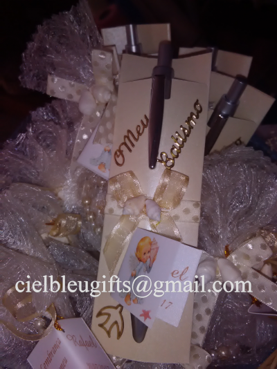 Canetas cinzentas em cartões bejes com laços dourados e decoração com anjo e folha.