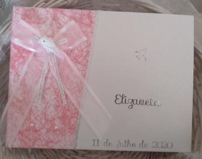 Livro decorativo rosa e branco com laço e texto prata numa superfície branca