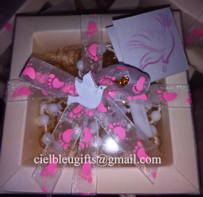 Caixa de oferta com fita cor-de-rosa, pomba branca e pulseira branca dentro