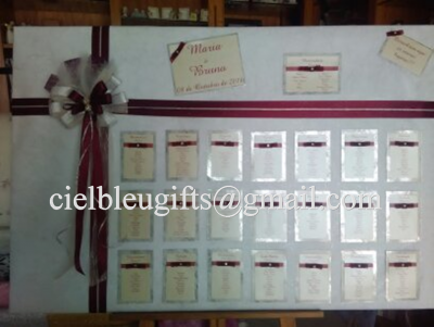 Quadro branco decorado com fita, laço e cartões de nomes para organização de assentos