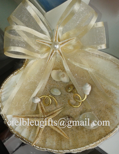 Prato decorativo em forma de concha com laço dourado, conchas e brincos dourados