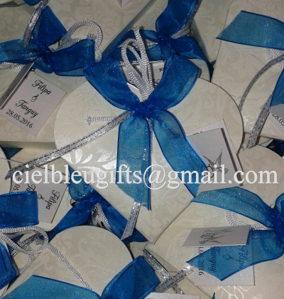 Caixas de presente em forma de coração com laços azuis e etiquetas com nomes e data