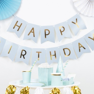 Decoração de festa com bandeirolas azuis claras e letras douradas a dizer HAPPY BIRTHDAY