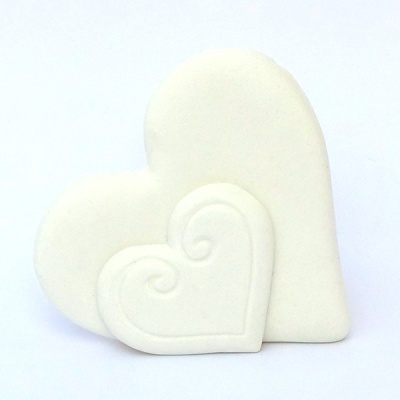 Dois corações brancos de cerâmica ou gesso sobre fundo branco