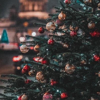 Árvore de Natal com decoração tradicional em ambiente noturno urbano