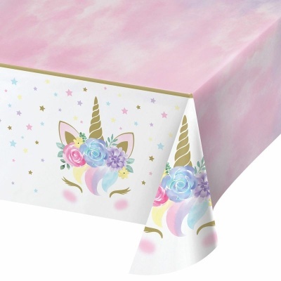 Toalha de mesa de plástico com padrão de unicórnio colorido e fundo rosa.