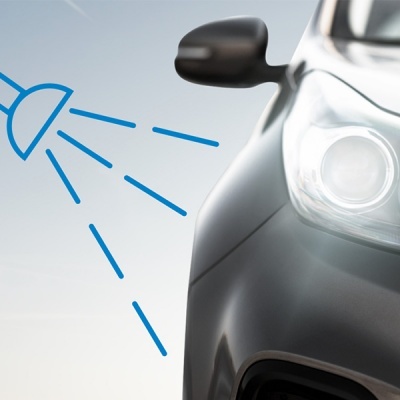 Frente de carro cinzento escuro com farol e espelho retrovisor preto