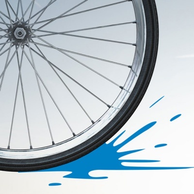 Roda de bicicleta com aro prateado e mancha azul no fundo branco