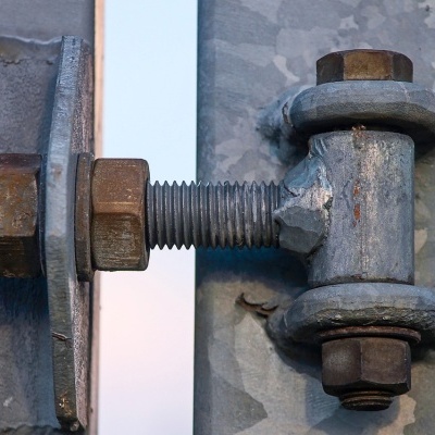 Parafusos e porcas metálicos em estrutura cinzenta com textura