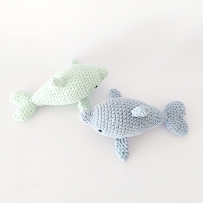 Dois golfinhos de crochê verde claro e cinza em fundo branco