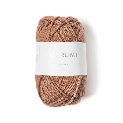 Novelo de lã castanha com rótulo branco e texto colorido e prateado