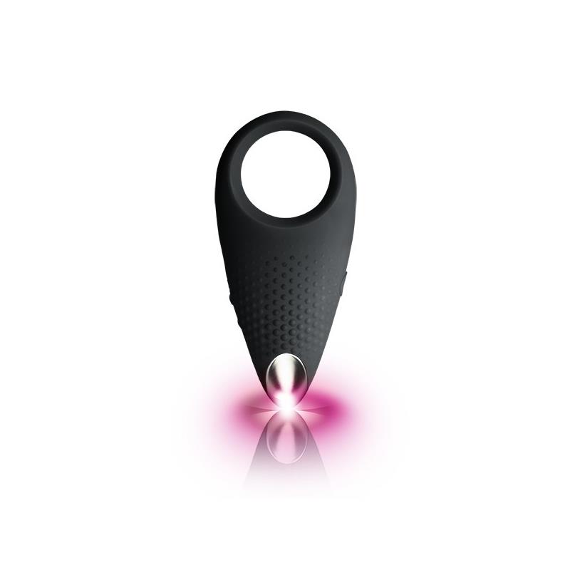 Anel sexual preto com textura e ponta metálica refletindo luz rosa