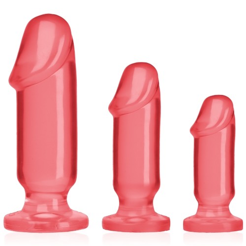 Três próteses sexuais rosa em diferentes tamanhos com base plana
