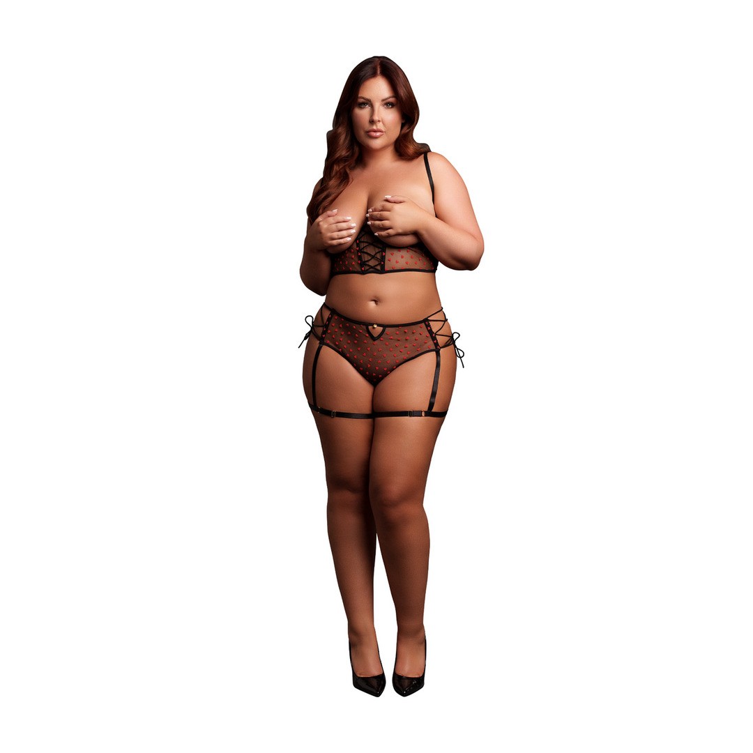 Mulher vestindo lingerie preta com corações vermelhos e sapatos de salto preto sobre fundo branco