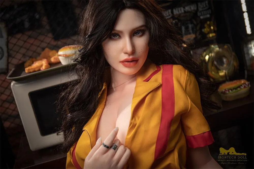 Boneca realista vestindo uniforme amarelo com vermelho em ambiente de cozinha