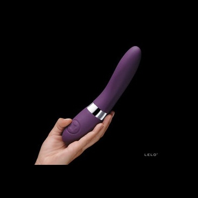 Vibrador roxo de silicone com detalhe prateado e botão, segurado por uma mão