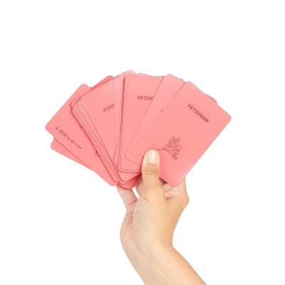 Mão a segurar cartas cor-de-rosa com palavras e desenho de flor
