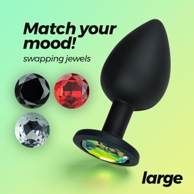 Plug anal preto com pedras facetadas para troca, fundo verde com texto.