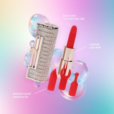 Vibrador formato baton metálico dourado com cristais e acessórios vermelhos de silicone em fundo colorido