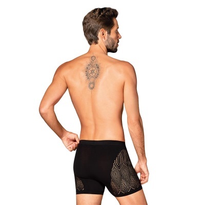 Homem de costas com boxers pretos e tatuagem nas costas