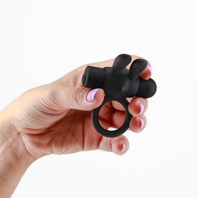 Anel preto de silicone com duas extensões sendo segurado por mão com unhas lilás