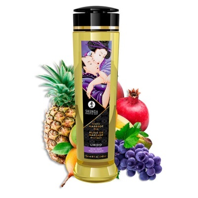 Frasco de óleo para massagem com frutas tropicais ao fundo