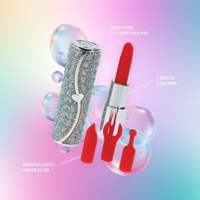 Dispositivo vibratório prateado com cristais azuis e acessórios vermelhos em silicone sobre fundo colorido