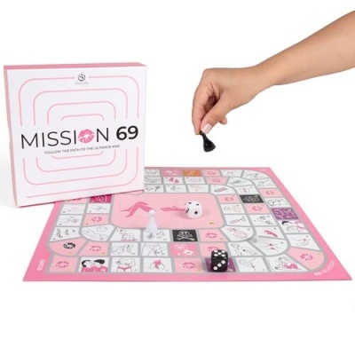 Jogo de tabuleiro MISSION 69 com caixa, dados e peças, mão humana a jogar.