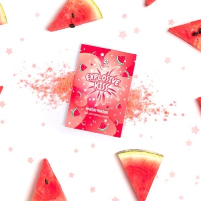 Pacote rosa de explosivos com sabor melancia rodeado por fatias de melancia e partículas rosa