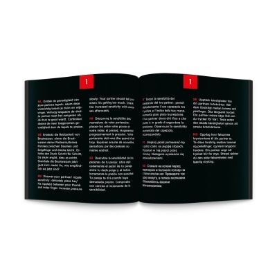 Livro aberto com texto multilingue impresso em páginas pretas e secções numeradas em vermelho