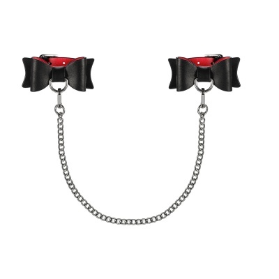 Algemas de couro preto com interior vermelho e laço, unidas por corrente metálica.